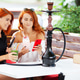 Two women smoke a hookah and enjoy cocktails in a cafe on the street Two women smoke a hookah and enjoy cocktails in a cafe on the street - PhotoDune Item for Sale
