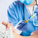 Female GP doctor holding ampoule vial with yellow liquid Female GP doctor holding ampoule vial with yellow liquid - PhotoDune Item for Sale