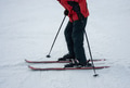 A man on alpine skis dressed in red ski jacket skiing down the ski slope. A man on alpine skis dressed in red ski jacket skiing down the ski slope. - PhotoDune Item for Sale