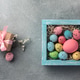 Colorful easter eggs in box and gift on table. Top view with copy space. Colorful easter eggs in box and gift on table. Top view with copy space. - PhotoDune Item for Sale