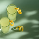Limoncello Glasses with Curled Lemon Peels on Light Green Background. Limoncello Glasses with Curled Lemon Peels on Light Green Background. - PhotoDune Item for Sale