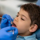 A dentist examines a boys teeth to prevent cavities and promote oral health. A dentist examines a boys teeth to prevent cavities and promote oral health. - PhotoDune Item for Sale