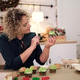 A woman in a green dress carefully decorates cupcakes resembling Christmas trees A woman in a green dress carefully decorates cupcakes resembling Christmas trees - PhotoDune Item for Sale