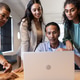 Diverse business team collaborating on laptop project in modern office setting Diverse business team collaborating on laptop project in modern office setting - PhotoDune Item for Sale
