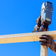 Construction worker uses nail gun to secure wood structure Construction worker uses nail gun to secure wood structure - PhotoDune Item for Sale