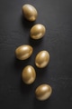 Chicken golden eggs on black. Easter dark concept. View from above. Chicken golden eggs on black. Easter dark concept. View from above. - PhotoDune Item for Sale