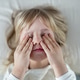 Scared child lying on bed covering eyes with hands expressing fear anxiety in bright bedroom Scared child lying on bed covering eyes with hands expressing fear anxiety in bright bedroom - PhotoDune Item for Sale