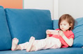 Thoughtful little toddler girl wear casual soft clothes lying on blue coach with smartphone and play Thoughtful little toddler girl wear casual soft clothes lying on blue coach with smartphone and play - PhotoDune Item for Sale