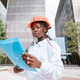 Professional female engineer in hardhat reading documents Professional female engineer in hardhat reading documents - PhotoDune Item for Sale