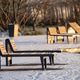 Empty wooden sunbeds for rest standing near river in city park covered in snow on sunny winter day. Empty wooden sunbeds for rest standing near river in city park covered in snow on sunny winter day. - PhotoDune Item for Sale