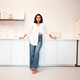 Woman in casual attire stands confidently in a modern kitchen Woman in casual attire stands confidently in a modern kitchen - PhotoDune Item for Sale