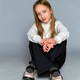 Thoughtful girl in textured sweater, perched casually chair. childhood elegance and relaxed attire. Thoughtful girl in textured sweater, perched casually chair. childhood elegance and relaxed attire. - PhotoDune Item for Sale