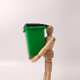 Green recycling bin toy being held by a wooden artist's mannequin Green recycling bin toy being held by a wooden artist's mannequin - PhotoDune Item for Sale