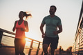 Happy couple jogging in sunset Happy couple jogging in sunset - PhotoDune Item for Sale