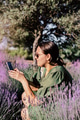 Young woman holding phone and making photos for social webs in summer lavender blooming field Young woman holding phone and making photos for social webs in summer lavender blooming field - PhotoDune Item for Sale
