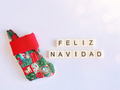Minimalistic flat lay with tiny stocking & Merry Christmas in Spanish written with tiles. Minimalistic flat lay with tiny stocking & Merry Christmas in Spanish written with tiles. - PhotoDune Item for Sale