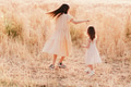 Two little girls wear casual dresses having fun in wheat field. Full length people. Kids in motion Two little girls wear casual dresses having fun in wheat field. Full length people. Kids in motion - PhotoDune Item for Sale