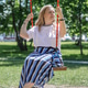 A blonde woman swinging on a swing in a park. Concept of freedom and happiness. Summertime. A blonde woman swinging on a swing in a park. Concept of freedom and happiness. Summertime. - PhotoDune Item for Sale