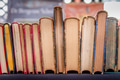 Second hand books in a row on a market stall. Old faded yellowing paper. Blurred background. Second hand books in a row on a market stall. Old faded yellowing paper. Blurred background. - PhotoDune Item for Sale