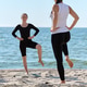 Adult women practicing yoga on sandy shore of Baltic Sea during clear day Adult women practicing yoga on sandy shore of Baltic Sea during clear day - PhotoDune Item for Sale