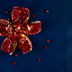 ripe pomegranate broken into pieces on blue wooden background ripe pomegranate broken into pieces on blue wooden background - PhotoDune Item for Sale