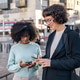 Two friends using smartphone in the street Two friends using smartphone in the street - PhotoDune Item for Sale