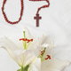 A symbolic Christian composition with christian cross lies beside a fresh white lily A symbolic Christian composition with christian cross lies beside a fresh white lily - PhotoDune Item for Sale