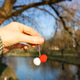 A traditional martisor in a girl's hand against the backdrop of a blurred park. A traditional martisor in a girl's hand against the backdrop of a blurred park. - PhotoDune Item for Sale
