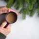 hands of an old man holding a cup of coffee on the background of a natural Christmas tree hands of an old man holding a cup of coffee on the background of a natural Christmas tree - PhotoDune Item for Sale