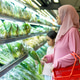 A Muslim mother in a pink hijab and her daughter shop for fresh vegetables in the supermarket. A Muslim mother in a pink hijab and her daughter shop for fresh vegetables in the supermarket. - PhotoDune Item for Sale