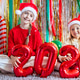 Smiling girls in Santa hats holding 2026 balloons at a festive indoor party Smiling girls in Santa hats holding 2026 balloons at a festive indoor party - PhotoDune Item for Sale