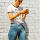 Texting and posting girl in front of a brick wall Texting and posting girl in front of a brick wall - PhotoDune Item for Sale