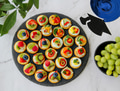 Overhead flat lay of colorful appetizers on marble counter decorated with graduation party supplies Overhead flat lay of colorful appetizers on marble counter decorated with graduation party supplies - PhotoDune Item for Sale