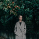 A beautiful elegant blonde woman in a coat stands in the garden under a ripe persimmon tree. A beautiful elegant blonde woman in a coat stands in the garden under a ripe persimmon tree. - PhotoDune Item for Sale