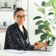 Happy pretty caucasian businesswoman wearing glasses, typing on a laptop at her desk in a bright Happy pretty caucasian businesswoman wearing glasses, typing on a laptop at her desk in a bright - PhotoDune Item for Sale