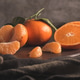 Tangerines and orange slices arranged on a dark wooden board Tangerines and orange slices arranged on a dark wooden board - PhotoDune Item for Sale
