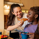 Lesbian couple sharing croissant during intimate home breakfast Lesbian couple sharing croissant during intimate home breakfast - PhotoDune Item for Sale