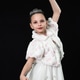 Elegant girl in white dress and tiara posing gracefully on black backdrop Elegant girl in white dress and tiara posing gracefully on black backdrop - PhotoDune Item for Sale