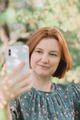 Close up portrait of red haired woman looking at screen of her smartphone Close up portrait of red haired woman looking at screen of her smartphone - PhotoDune Item for Sale