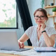 Middle aged smiling woman working with laptop, looking at camera, sitting at home Middle aged smiling woman working with laptop, looking at camera, sitting at home - PhotoDune Item for Sale