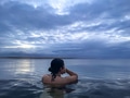 Woman from behind thinkin in an infinity hot pool looking at the ocean with her hand on the face Woman from behind thinkin in an infinity hot pool looking at the ocean with her hand on the face - PhotoDune Item for Sale