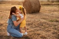Happy girl child in yellow dress hugs young mom in autumn field Happy girl child in yellow dress hugs young mom in autumn field - PhotoDune Item for Sale