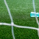 Water bottle on the green grass of a soccer field with net Water bottle on the green grass of a soccer field with net - PhotoDune Item for Sale