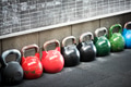 Row of colorful kettlebell weights in a gym Row of colorful kettlebell weights in a gym - PhotoDune Item for Sale