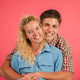couple embracing each other with smiles while looking at the camera against a bright pink backdrop couple embracing each other with smiles while looking at the camera against a bright pink backdrop - PhotoDune Item for Sale