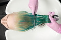 Top View of Hairdresser Holds Hair in Hand and Combs Long Green Hair While Washing Hair in Shower Top View of Hairdresser Holds Hair in Hand and Combs Long Green Hair While Washing Hair in Shower - PhotoDune Item for Sale