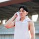 Asian man in white tank top is standing and wiping sweat with towel, taking a rest after running. Asian man in white tank top is standing and wiping sweat with towel, taking a rest after running. - PhotoDune Item for Sale