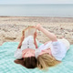 Two women reading together on beach blanket by sea Two women reading together on beach blanket by sea - PhotoDune Item for Sale