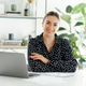 Confident pretty businesswoman sitting at a desk with laptop, looking and smiling at the camera Confident pretty businesswoman sitting at a desk with laptop, looking and smiling at the camera - PhotoDune Item for Sale