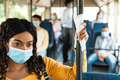 Black female in face mask standing in bus using tissue Black female in face mask standing in bus using tissue - PhotoDune Item for Sale